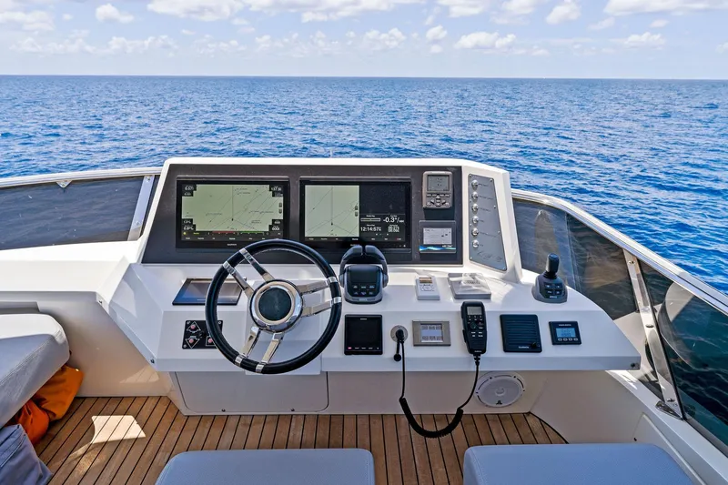 Slide: The Image of Helm of 2014 Lazzara 64 yacht with navigation screens, steering wheel, and ocean view. - 38