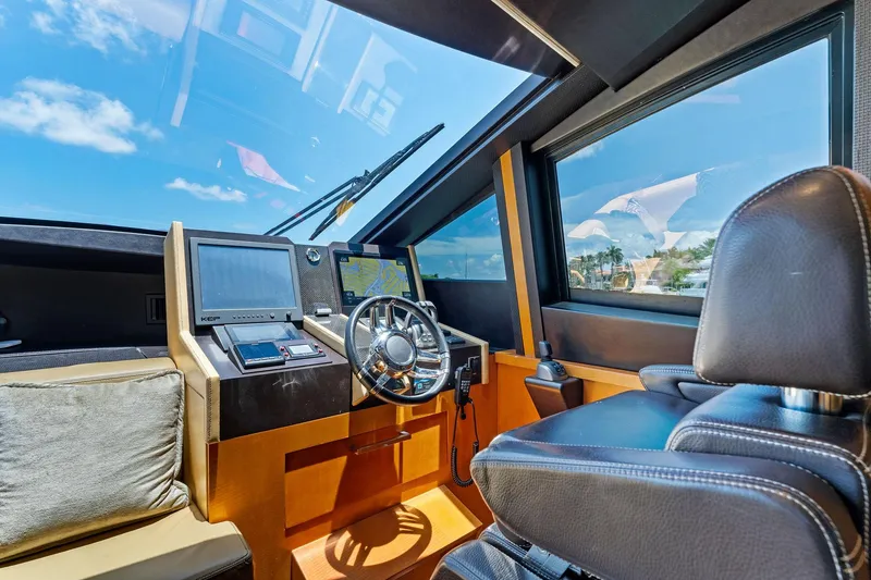 Slide: The Image of Luxurious helm of 2014 Lazzara 64 yacht with modern navigation equipment and leather seating. - 59