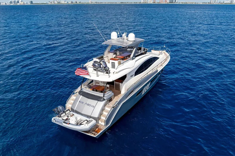 Slide: The Image of Luxurious 2014 Lazzara 64 yacht cruising on open blue waters, city skyline in background. - 76