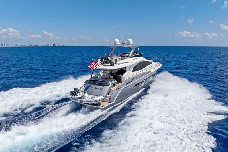 Slide: The Image of Luxurious 2014 Lazzara 64 yacht cruising on open ocean under clear blue sky. - 84