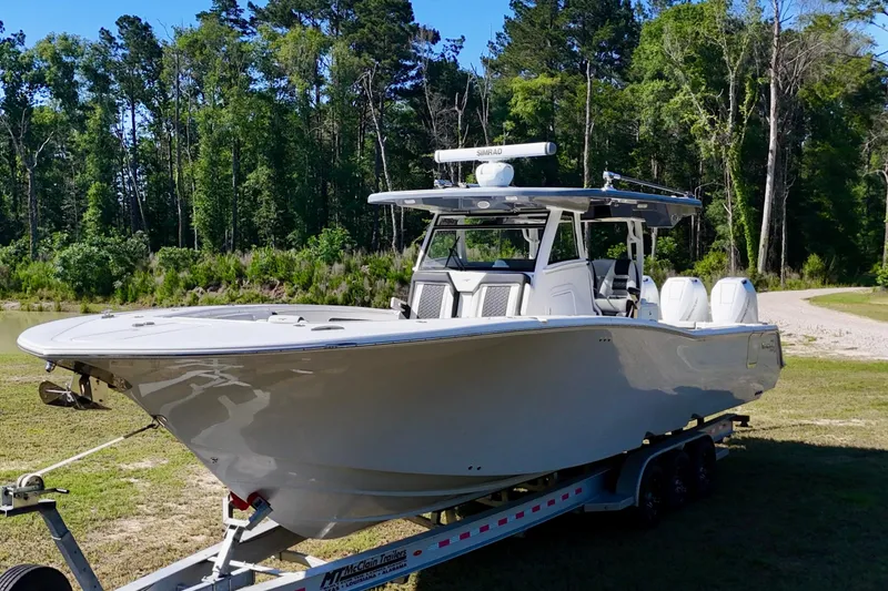 Slide: The Image of 2024 Tidewater 380 CC Adventure boat on trailer in a wooded area. - 10
