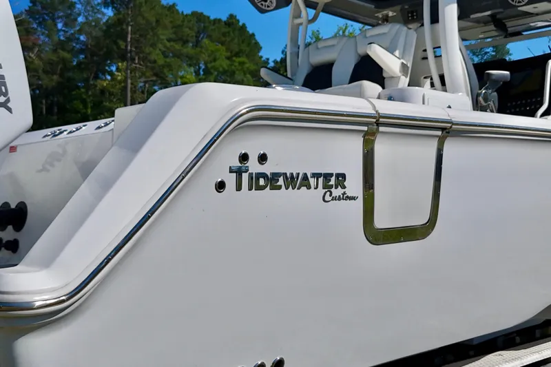 Slide: The Image of 2024 Tidewater 380 CC Adventure boat, sleek design with custom detailing, docked outdoors. - 13