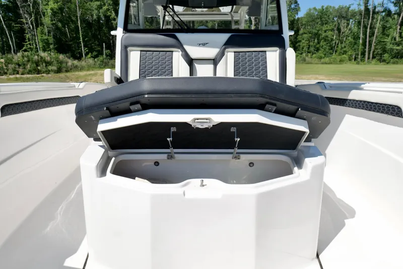 Slide: The Image of 2024 Tidewater 380 CC Adventure boat with open storage compartment and cushioned seating. - 37