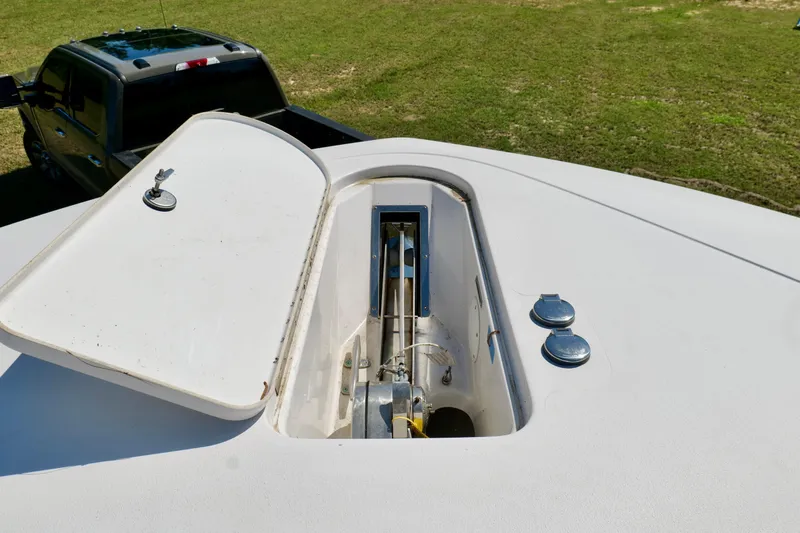 Slide: The Image of 2024 Tidewater 380 CC Adventure boat anchor compartment, open lid, with truck in background. - 39