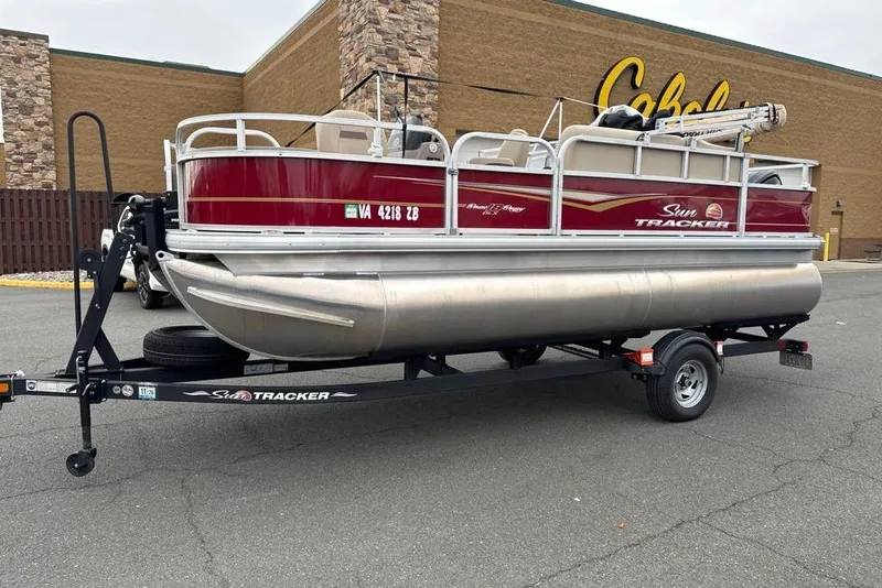 The Image of 2024 Sun Tracker Bass Buggy 18 DLX pontoon boat on trailer, parked outside Cabela's. - 0