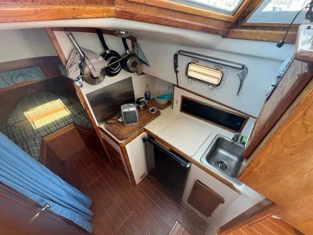 Slide: The Image of Interior of a 1989 Cape Dory Flybridge Cruiser with kitchen and sleeping area. - 10