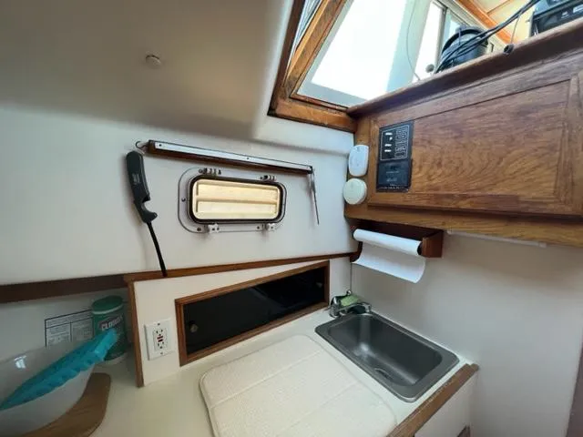 Slide: The Image of Interior of 1989 Cape Dory Flybridge Cruiser with sink and wooden cabinets. - 13