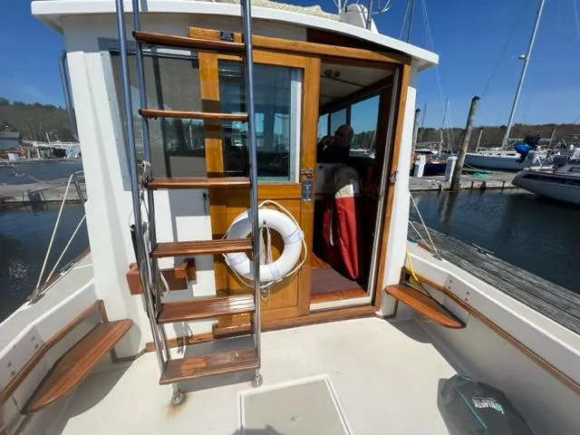 Slide: The Image of 1989 Cape Dory Flybridge Cruiser at dock with wooden door and ladder. - 14