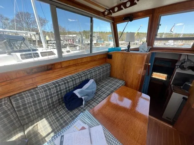 Slide: The Image of Interior of a 1989 Cape Dory Flybridge Cruiser with wooden table and bench seating. - 3