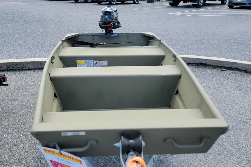 Slide: The Image of 2025 Tracker Grizzly 10 Jon boat with motor, parked on asphalt. - 7