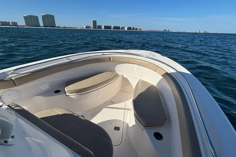 Slide: The Image of 2015 Pursuit S 280 Sport boat on open water with city skyline. - 16
