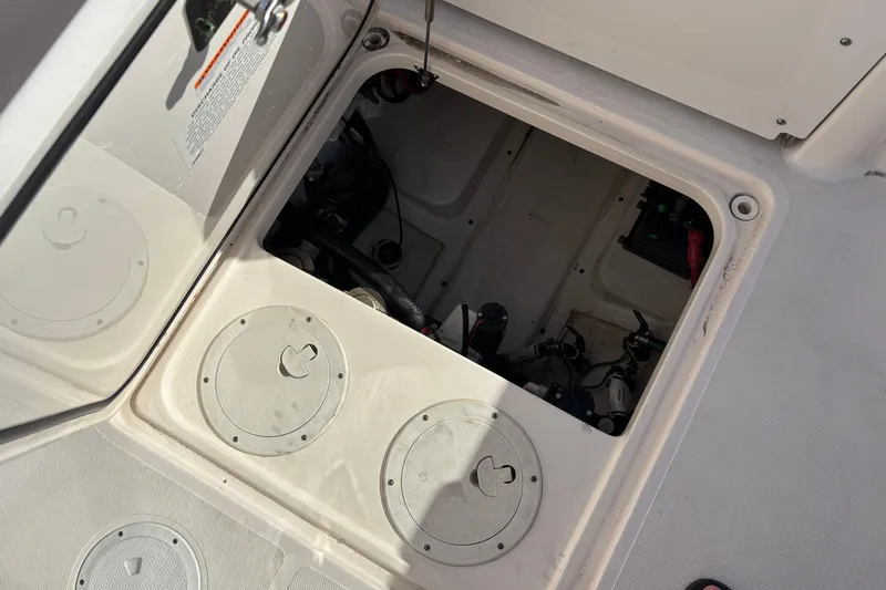 Slide: The Image of Open hatch on 2015 Pursuit S 280 Sport boat, revealing internal components and storage area. - 29