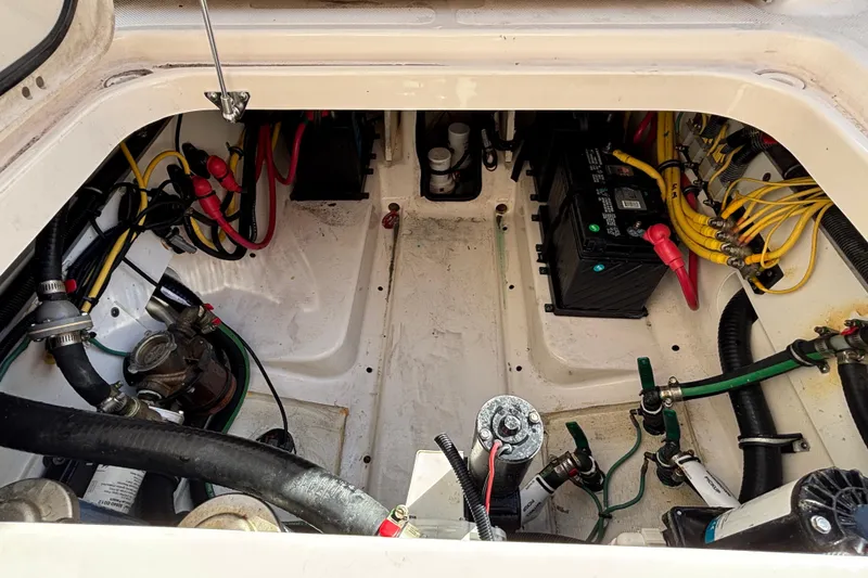Slide: The Image of Engine compartment of a 2015 Pursuit S 280 Sport boat, showing wiring and battery setup. - 31