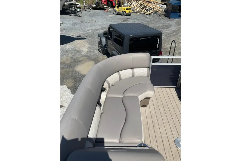Slide: The Image of 2019 Bennington SX 20 SSRX pontoon boat with beige seating, parked near a black SUV. - 10