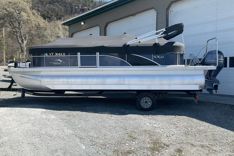 The Image of 2019 Bennington SX 20 SSRX pontoon boat on trailer, parked outdoors. - 2