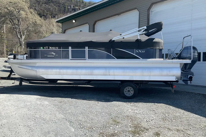 Slide: The Image of 2019 Bennington SX 20 SSRX pontoon boat on trailer, parked outdoors. - 3