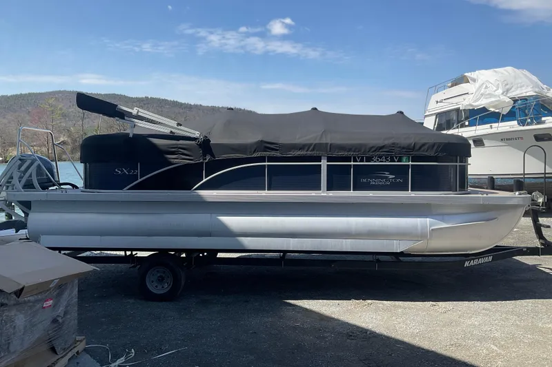 Slide: The Image of 2019 Bennington SX 20 SSRX pontoon boat with cover, parked on trailer. - 6