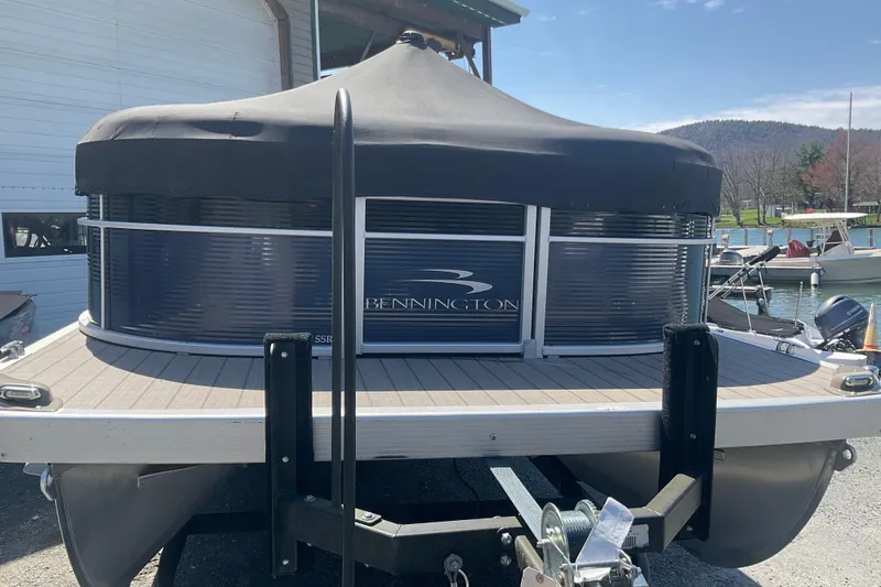Slide: The Image of 2019 Bennington SX 20 SSRX pontoon boat with cover, docked near a marina. - 7