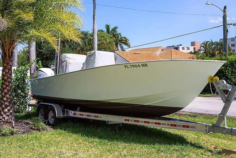 Slide: The Image of 2007 Speed Sport 25 boat on trailer, parked outdoors near palm trees. - 2