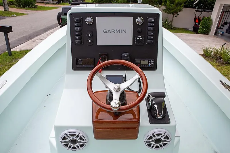 Slide: The Image of 2007 Speed Sport 25 boat dashboard with Garmin navigation and wooden steering wheel. - 4