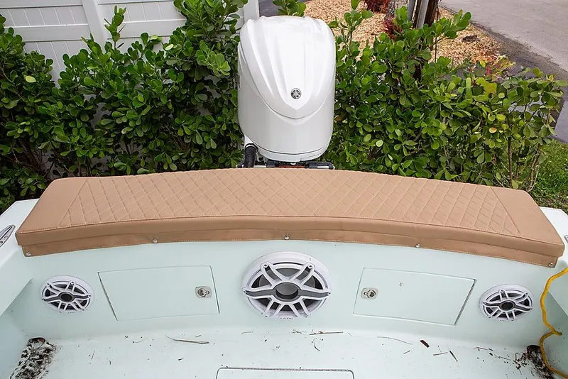 Slide: The Image of 2007 Speed Sport 25 boat with cushioned seating and outboard motor, surrounded by greenery. - 8