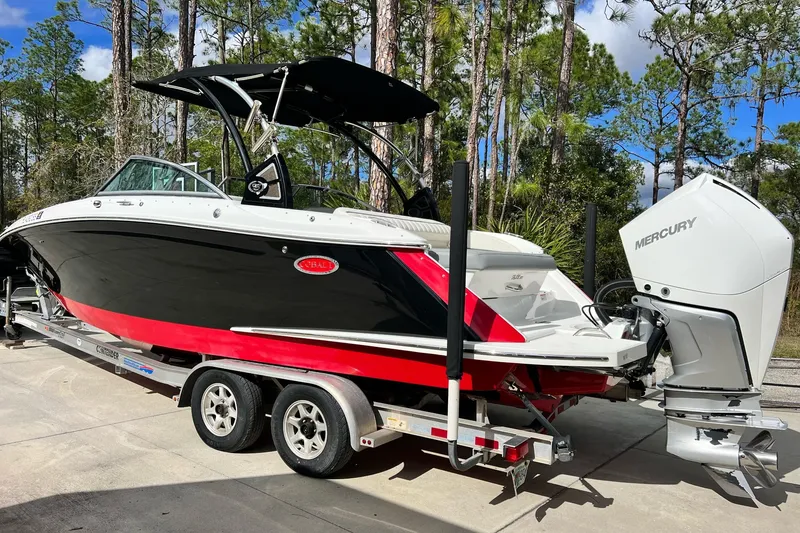 The Image of 2019 Cobalt 25SC boat on trailer with Mercury outboard, parked outdoors. - 0
