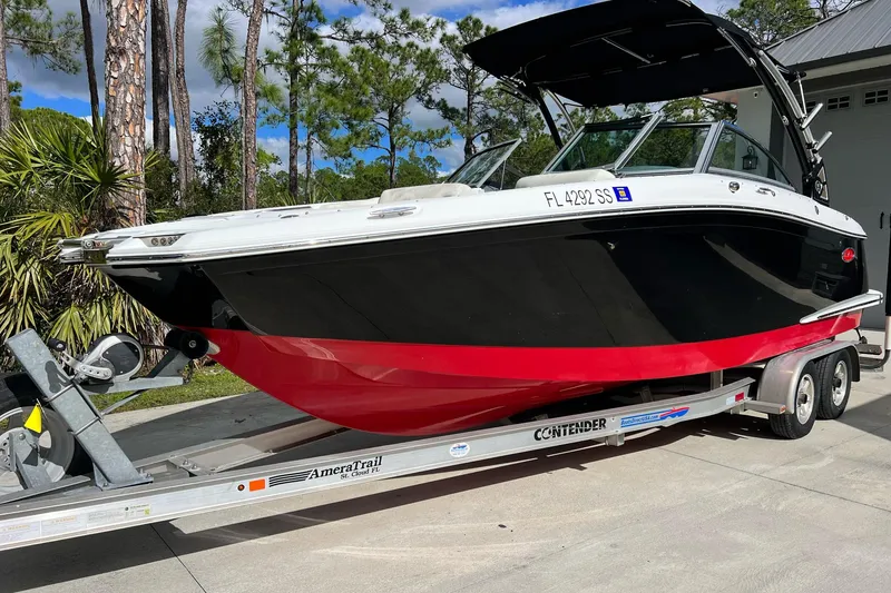 Slide: The Image of 2019 Cobalt 25SC boat on trailer, black and red hull, parked outdoors. - 1