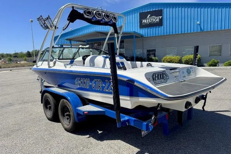 Slide: The Image of Blue and white 2002 Gekko GTR-22 boat on trailer outside Prestige Water Sports building. - 10