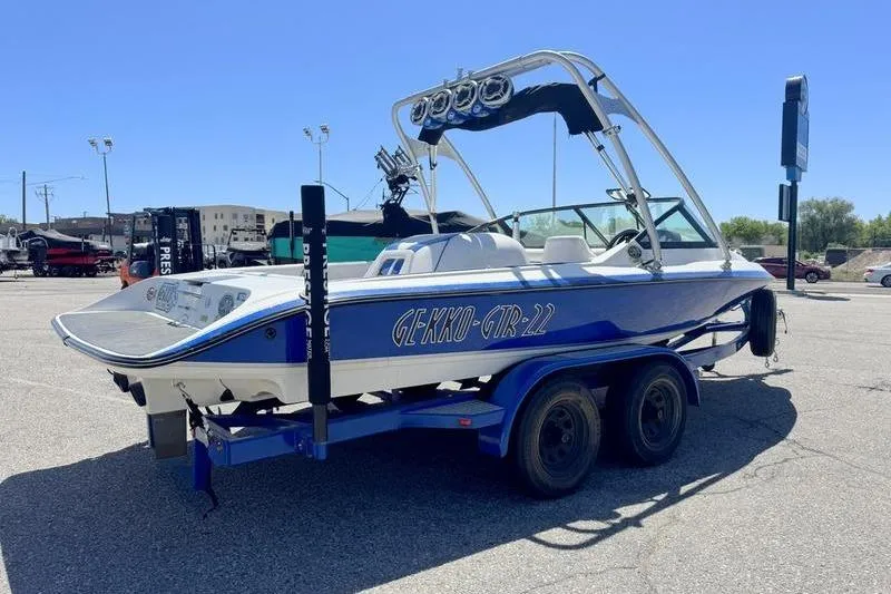 Slide: The Image of 2002 Gekko GTR-22 boat on trailer in parking lot under clear blue sky. - 11