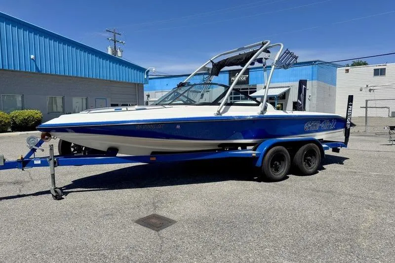 Slide: The Image of 2002 Gekko GTR-22 boat on trailer, parked outdoors near blue building. - 8