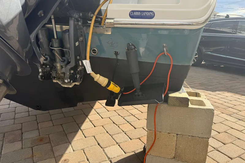 Slide: The Image of Rear view of a 2012 Sailfish 2680 WAC boat on blocks, showing engine and cables. - 11