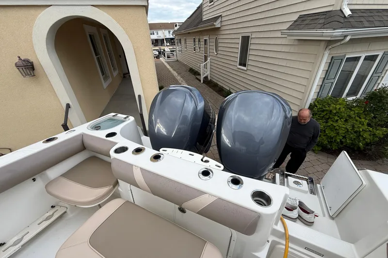 Slide: The Image of 2012 Sailfish 2680 WAC boat with dual engines, docked near residential homes. - 14