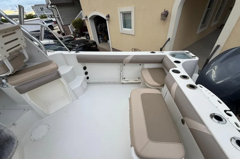 Slide: The Image of Interior view of a 2012 Sailfish 2680 WAC boat, featuring beige seating and cup holders. - 15