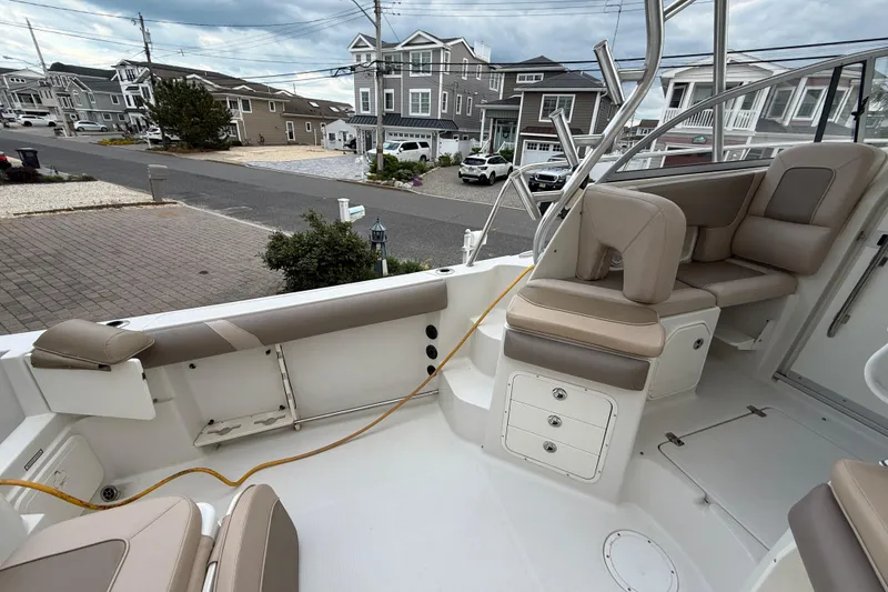 Slide: The Image of 2012 Sailfish 2680 WAC boat interior with beige seating, docked in a residential area. - 18