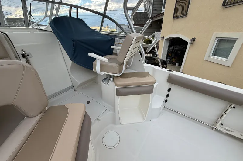 Slide: The Image of 2012 Sailfish 2680 WAC boat interior with beige seating and covered helm. - 20