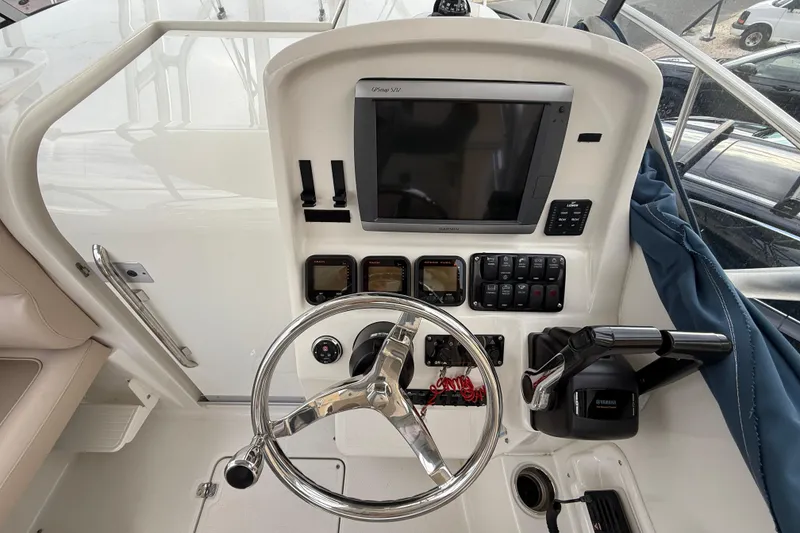 Slide: The Image of 2012 Sailfish 2680 WAC boat dashboard with steering wheel and navigation controls. - 25