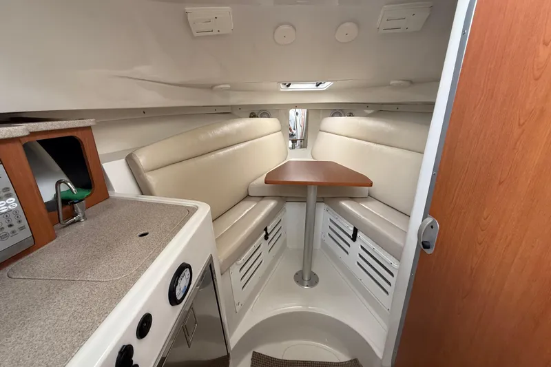 Slide: The Image of Interior of 2012 Sailfish 2680 WAC boat with seating and compact kitchenette. - 27