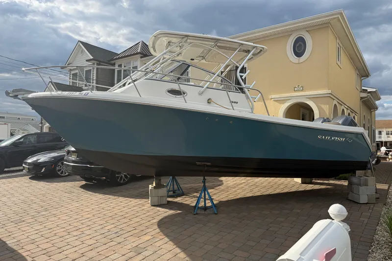 Slide: The Image of 2012 Sailfish 2680 WAC boat on stands in driveway, near residential homes. - 3