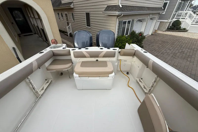 Slide: The Image of 2012 Sailfish 2680 WAC boat interior with seating and storage, docked near a house. - 31