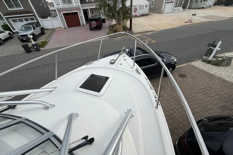 Slide: The Image of 2012 Sailfish 2680 WAC boat parked in residential driveway, surrounded by houses and cars. - 4