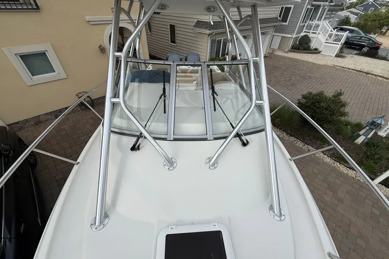 Slide: The Image of 2012 Sailfish 2680 WAC boat with sleek design, parked in a residential driveway. - 5