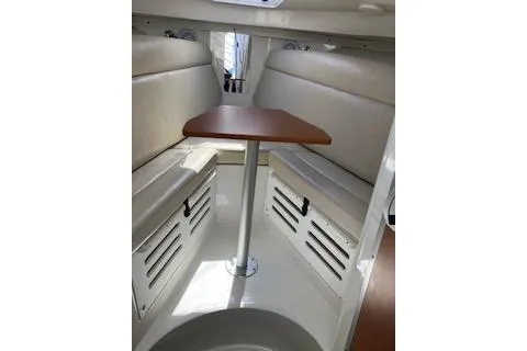 Slide: The Image of 2012 Sailfish 2680 WAC cabin interior with beige seating and wooden table. - 9
