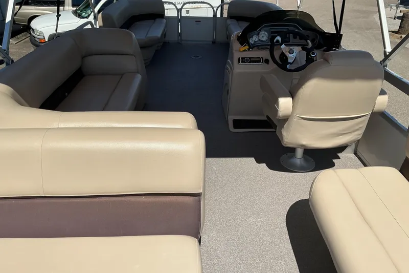 Slide: The Image of 2017 Sun Tracker Party Barge 24 DLX interior with beige seating and steering console. - 15