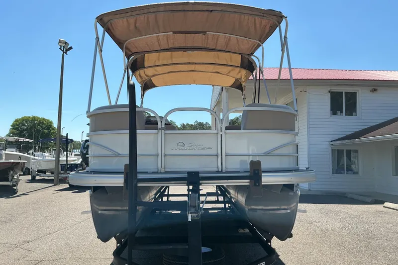 Slide: The Image of 2017 Sun Tracker Party Barge 24 DLX pontoon boat with canopy, parked outdoors. - 2