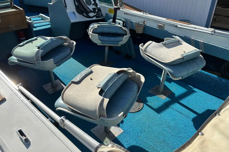 Slide: The Image of 1983 Crestliner 16 boat interior with blue carpet and four swivel seats. - 11