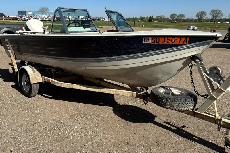 Slide: The Image of 1983 Crestliner 16 boat on trailer, parked outdoors on a sunny day. - 4
