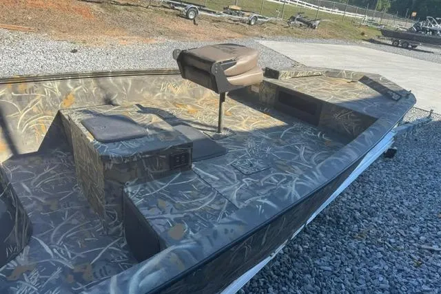 Slide: The Image of 2026 War Eagle 2170 Blackhawk boat with camouflage design on gravel surface. - 12