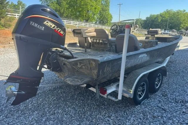 Slide: The Image of 2026 War Eagle 2170 Blackhawk boat with Yamaha engine on a trailer, parked on gravel. - 9