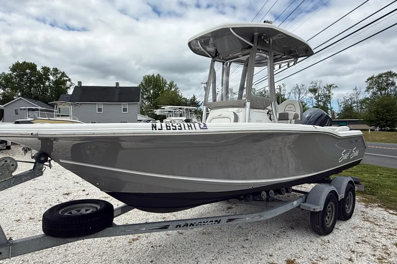 Slide: The Image of 2016 Tidewater 210 LXF boat on trailer, parked outdoors, with overcast sky. - 2