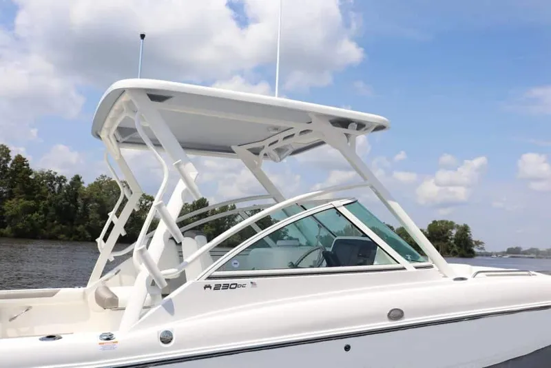 Slide: The Image of Manufacturer Provided Image: 2026 World Cat 230 DC boat with sleek design and canopy, on a calm river. - 2